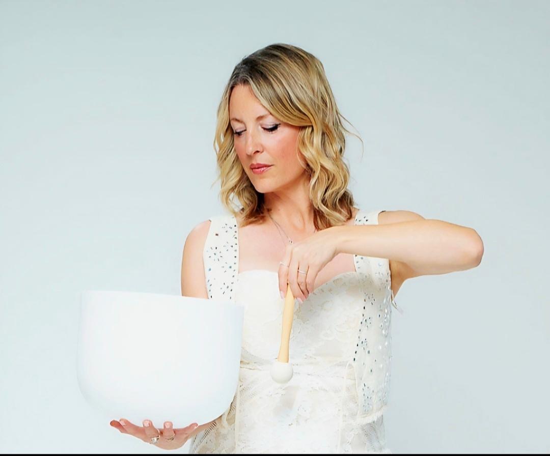 Mia playing a white crystal singing bowl